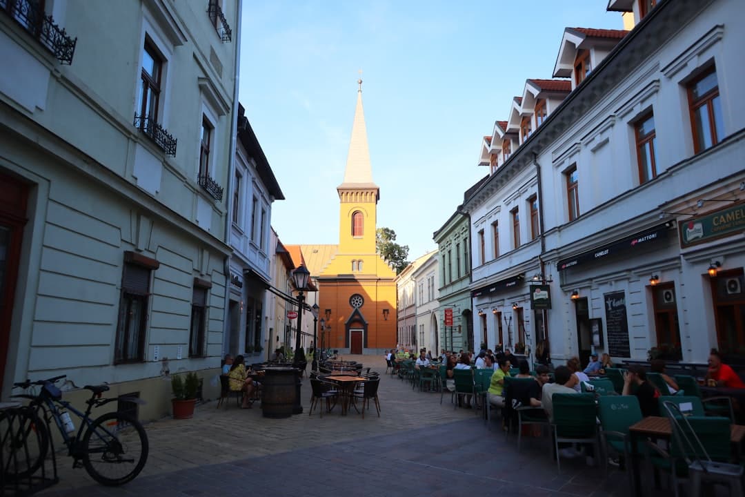 A city street with a church steeple in the background